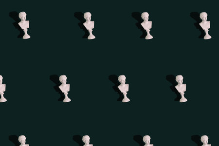 Mini bust of greece statue, concept repetition of bust on green backgroundの写真素材