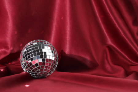 Party silver mirror ball on red silk backdrop, party conceptの写真素材