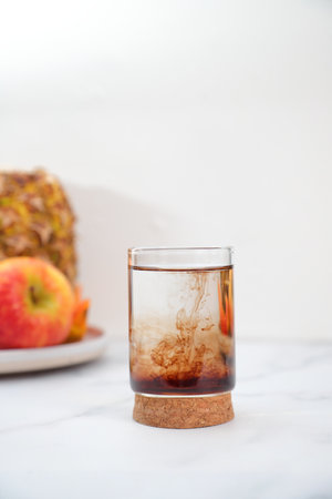 Natural brown supplements liquid vitamins drop in glass of water with pipette, lifestyleの写真素材