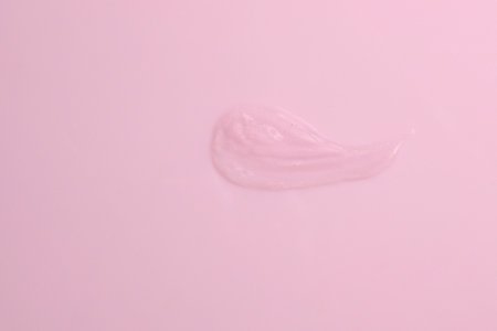 Transparent cream smash on pink background, serum textureの写真素材