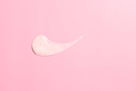 White cream smash on pink background, cosmetic texture smearの写真素材