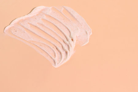 Exfolaliate peeling scrub texture on beige background, cream smash