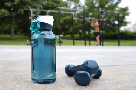 Sport water bottle and barbell on sport workout background, training equipment, lifestyle stagingの写真素材