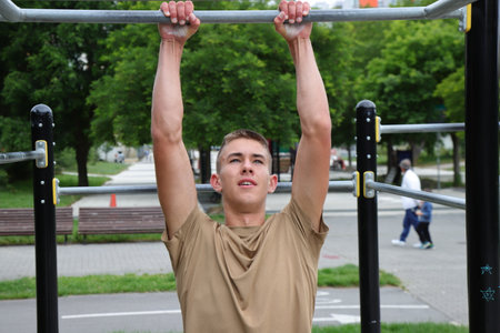 Young boy, teenager doing outdoor sport, workout on horizontal bar, healthy sport life