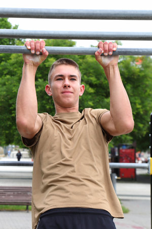Young boy, teenager doing outdoor sport, workout on horizontal bar, healthy sport lifeの写真素材