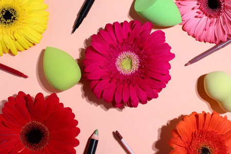 Cosmetic set with blender, facial makeup sponge for foundation applying with gerbera flowers, beauty conceptの写真素材