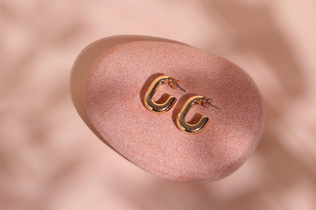 Golden luxury earrings on natural stone, trendy jewelryの写真素材