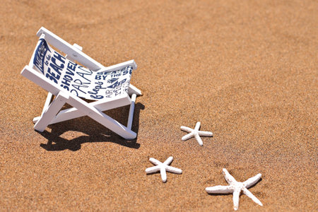 Beach bed on sand and shells, summer vacation relax chair on ocean coastの写真素材