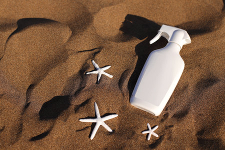 Sunscreen bottle on sand, beach cosmetic, skin health careの写真素材