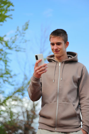 Teenager boy with smartphone, looking at phoneの写真素材