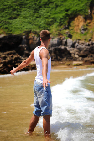 Young caucasian guy in sunglasses on the beach, casual teenager style, summer lifestyleの写真素材