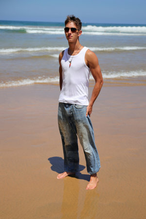 Young caucasian guy in sunglasses on the beach, casual teenager style, summer lifestyleの写真素材