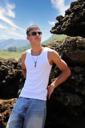 Young caucasian guy in sunglasses on the beach, casual teenager style, summer lifestyleの写真素材