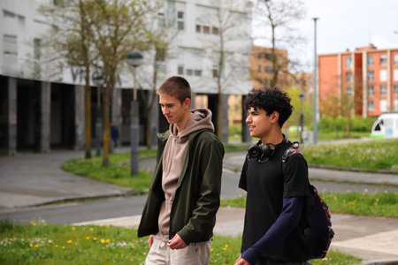 Two teenager boy walking on street, race diversity, students portraitsの写真素材