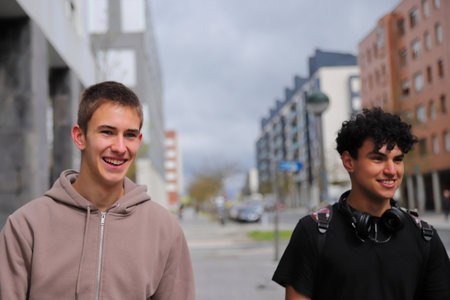 Two teenager boy walking on street, race diversity, students portraitsの写真素材