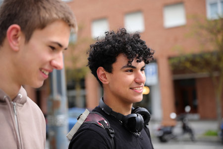 Two teenager boy walking on street, race diversity, students portraitsの写真素材