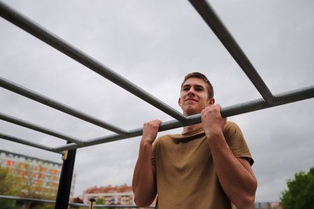 Young teenage male doing workout on sport bars, healthy lifestyle, outdoor fitness concept