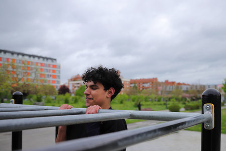 Young teenage male doing workout on sport bars, healthy lifestyle, outdoor fitness concept
