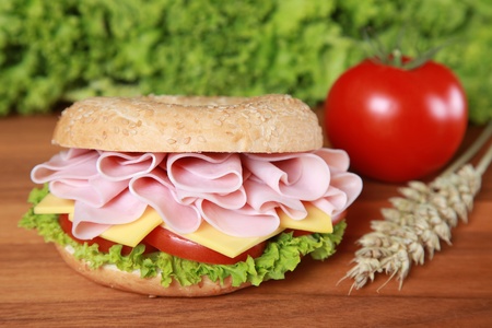 Fresh bagel with ham, tomatos, cheese and lettuceの写真素材