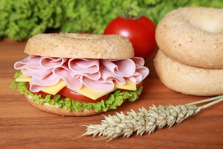 Fresh bagel with ham, tomatos, cheese and lettuceの写真素材