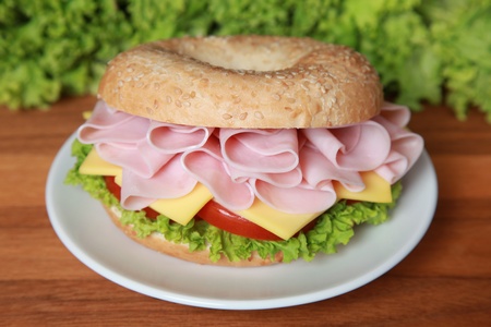 Fresh bagel with ham, tomatos, cheese and lettuceの写真素材
