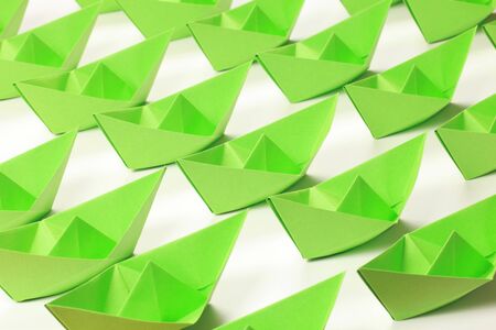 Several green paper boats on white backgroundの写真素材