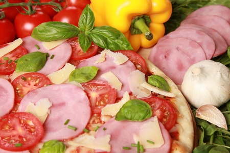 Pizza with ham, cheese, tomatoes and lettuceの写真素材