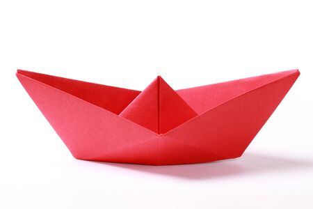 Closeup of a red paper boat on white backgroundの写真素材