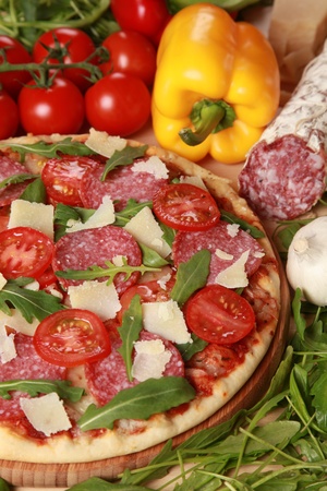 Pizza with salami, cheese, tomatoes and lettuceの写真素材
