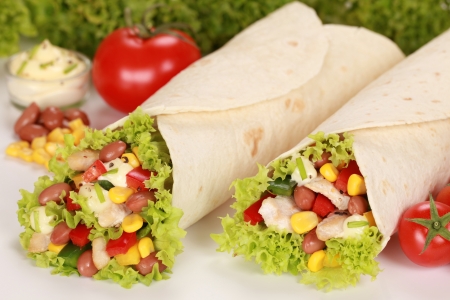 Chicken wrap sandwiches filled with beans, lettuce and cornの写真素材