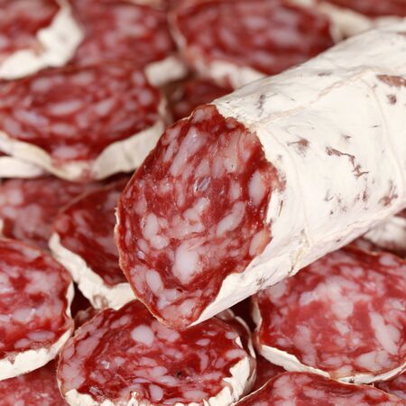 Original Salami from Italy with slices as backgroundの写真素材