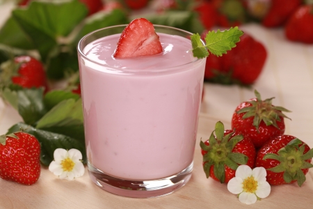 Fresh Yogurt in a jar with Strawberries, leaves and blossomsの写真素材
