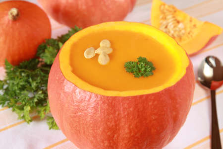 Pumpkin soup in a pumpkin and more pumpkins in the backgroundの写真素材