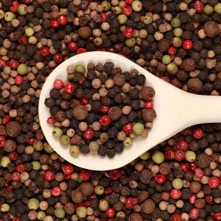 A wooden spoon on colorful four seasons pepperの写真素材