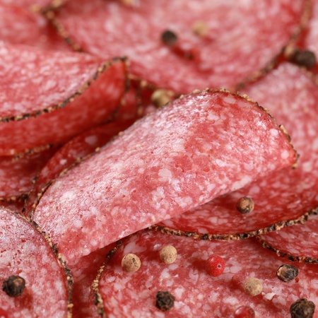 Salami in slices with peppery edge decorated with pepperの写真素材