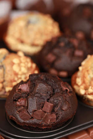 Chocolate and blueberry muffins in a baking sheetの写真素材