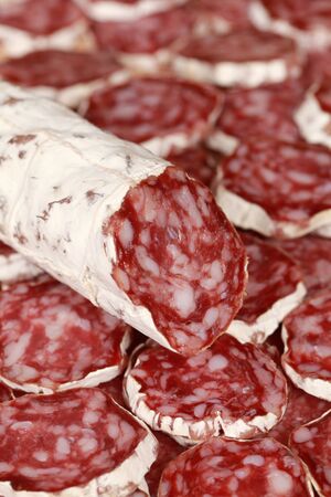 Original Salami from Italy with slices as backgroundの写真素材