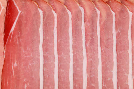 Smoked ham cut in slices as a backgroundの写真素材