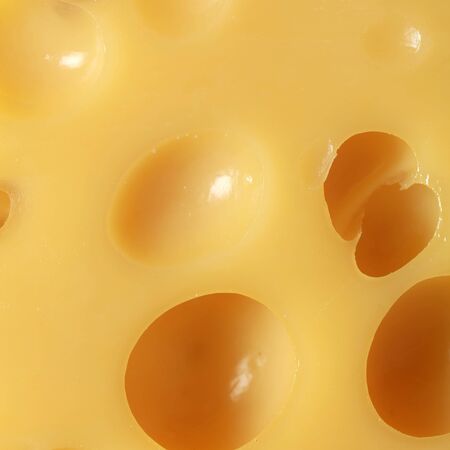 Emmental cheese with many holes forming a background