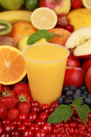 A glass of orange juice surrounded by fresh fruitsの写真素材