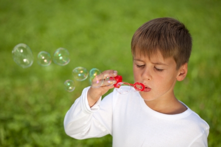 Little boy having fun with bubbles. Shallow depth of field.の写真素材