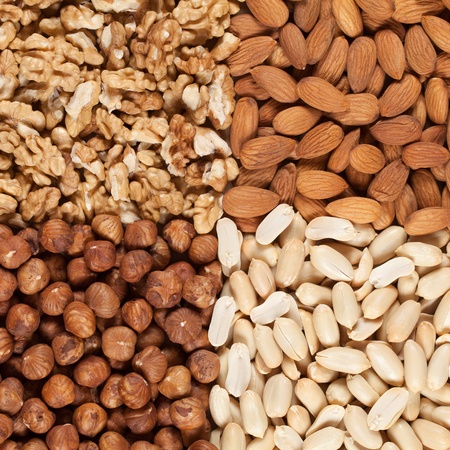 Peanuts, walnuts, almonds and hazelnuts forming a backgroundの写真素材