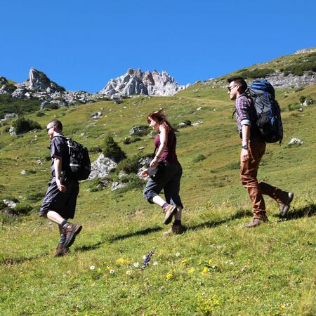 Three young backpackers hiking in the mountainsの写真素材