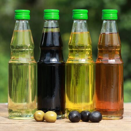 Collection of cooking oil in small bottles on a wooden tableの写真素材