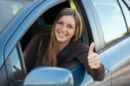 A happy driver leaning out of the window and showing thumbs up