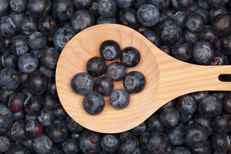 Group of fresh blueberries on a wooden spoonの写真素材