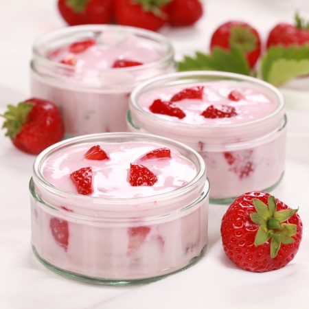 Strawberry yogurt served with fresh strawberries in glass bowlsの写真素材