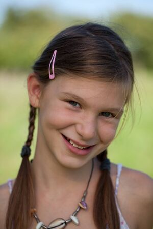 Portrait of a happy smiling young girl with braidsの写真素材