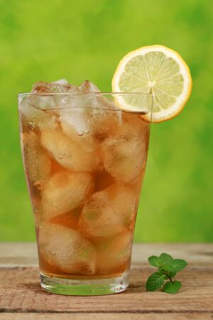 Cool ice tea with ice cubes and a slice of lemonの写真素材