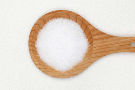 Sugar on a wooden spoon forming a backgroundの写真素材